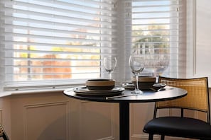 A dining area with a table set for two, two wine glasses, and plates. - Hartlepool Marina Retreat 2BR Sleeps 4 by Stay With Us (Hartlepool)