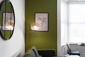 A room with a green wall, a framed picture, a floor lamp, and a window with blinds. - Hartlepool Marina Retreat 2BR Sleeps 4 by Stay With Us (Hartlepool)