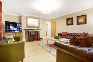 A living room with a fireplace, a television, a sofa, and a coffee table. - Luxurious Hot Tub Getaway Cottage Free Parking (Bishop Auckland)