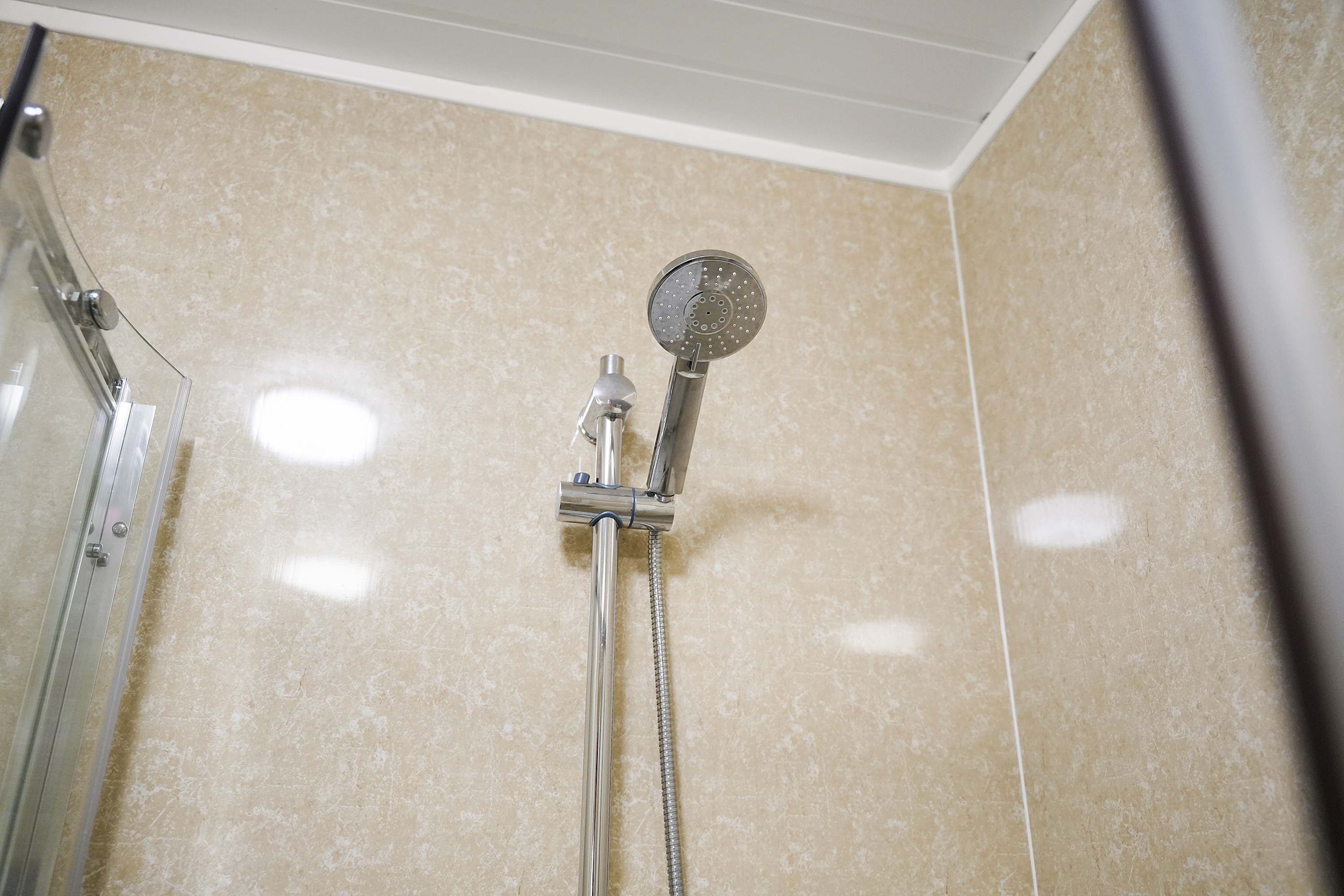 Ducha con cabezal de ducha de mano y grifería empotrada.