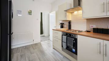 A modern kitchen with a refrigerator, stove, oven, and cabinets.