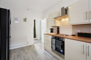 A modern kitchen with a refrigerator, stove, oven, and cabinets.