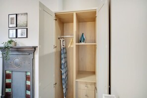 A room with a wooden wardrobe, a radiator, and a framed picture on the wall. - Spacious and Comfty 1 Bedroom Haven in Hartlepool (Hartlepool)