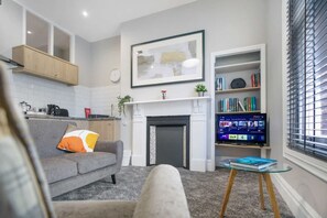 A modern living room with a fireplace, a sofa, a coffee table, and a bookshelf. - Spacious and Comfty 1 Bedroom Haven in Hartlepool (Hartlepool)