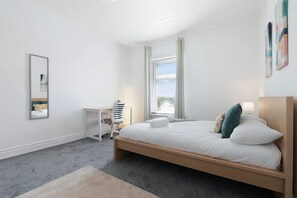 A bedroom with a bed, a desk, a chair, and a window. - 4BR on Durham Road Perfect For Large Groups (Stanley)