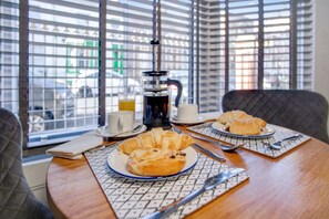 A breakfast table with croissants, a coffee pot, and a cup of coffee. - Stylish 1BR Home Near Station by Stay With Us (Hartlepool)