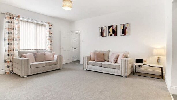 A spacious living room with two sofas, a coffee table, and a side table with a lamp. - Stylish 2BR House in Ashington by Stay With Us (Ashington)