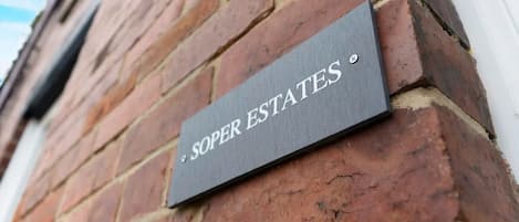 A brick wall with a sign that reads 'SOPER ESTATES'.