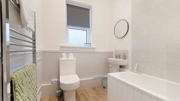Un baño moderno con inodoro, lavabo y bañera.