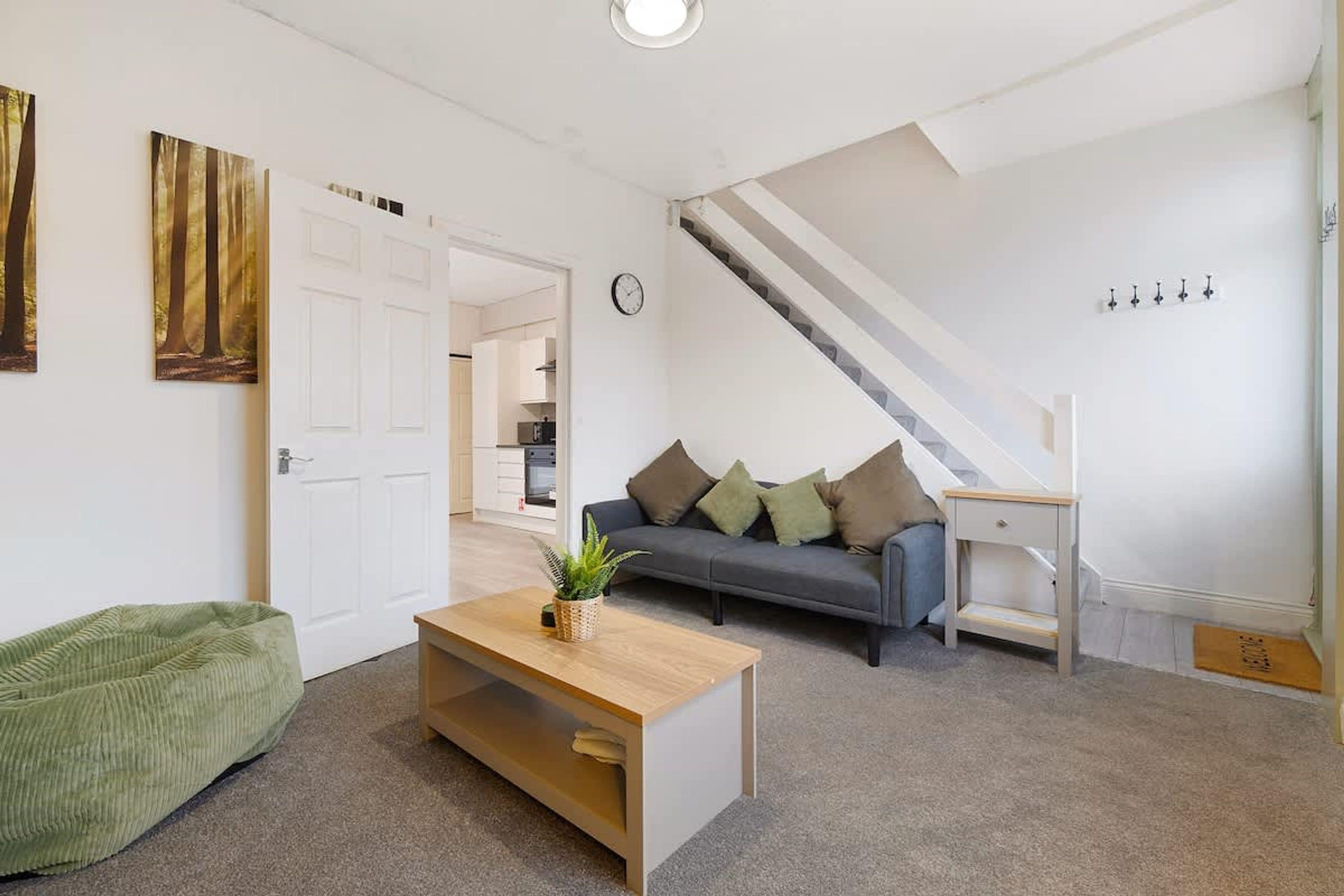 Una sala de estar moderna con un sofá, una mesa de centro y una escalera.