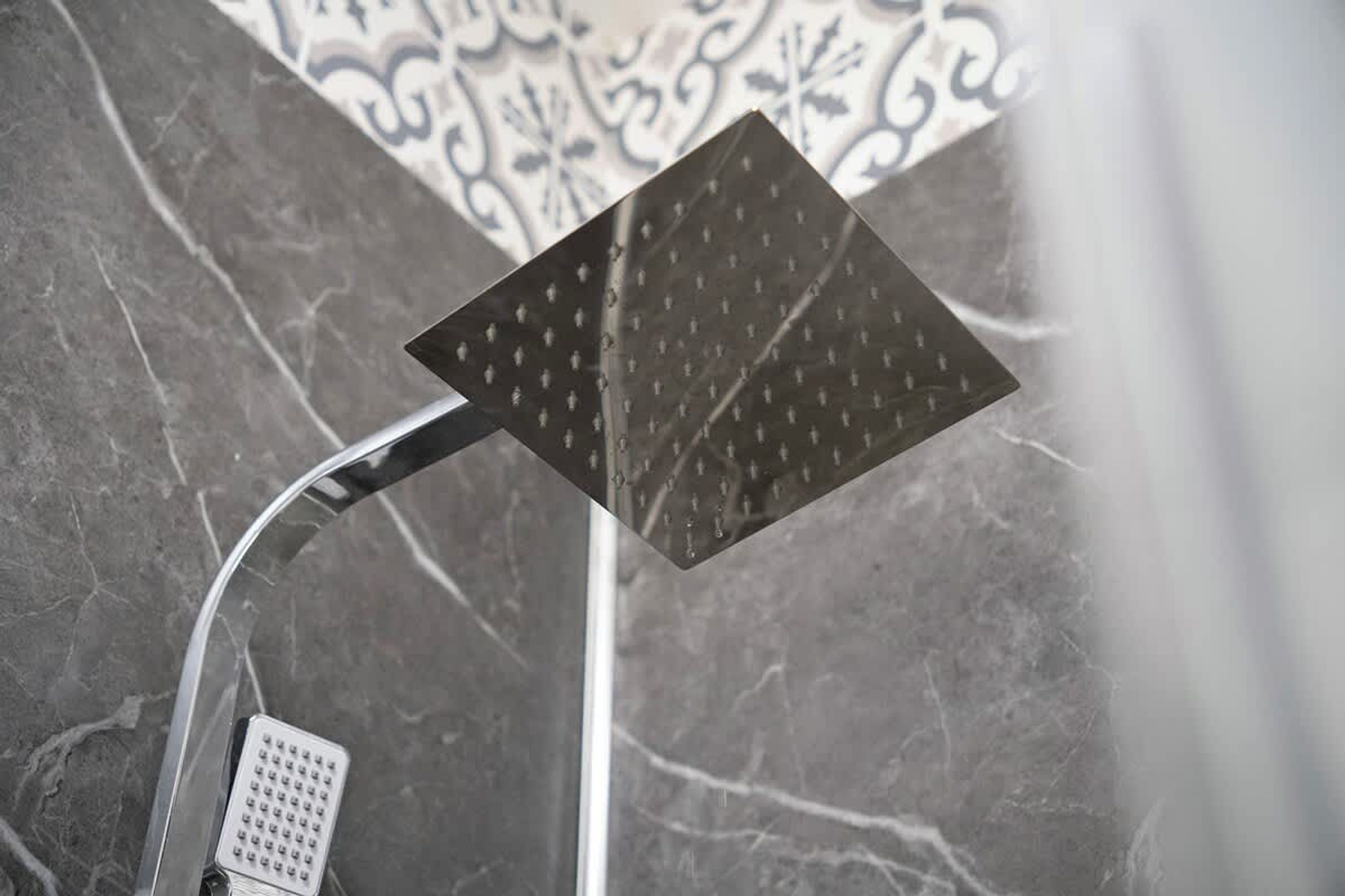 Un cabezal de ducha con diseño cuadrado y un panel de control de forma cuadrada.