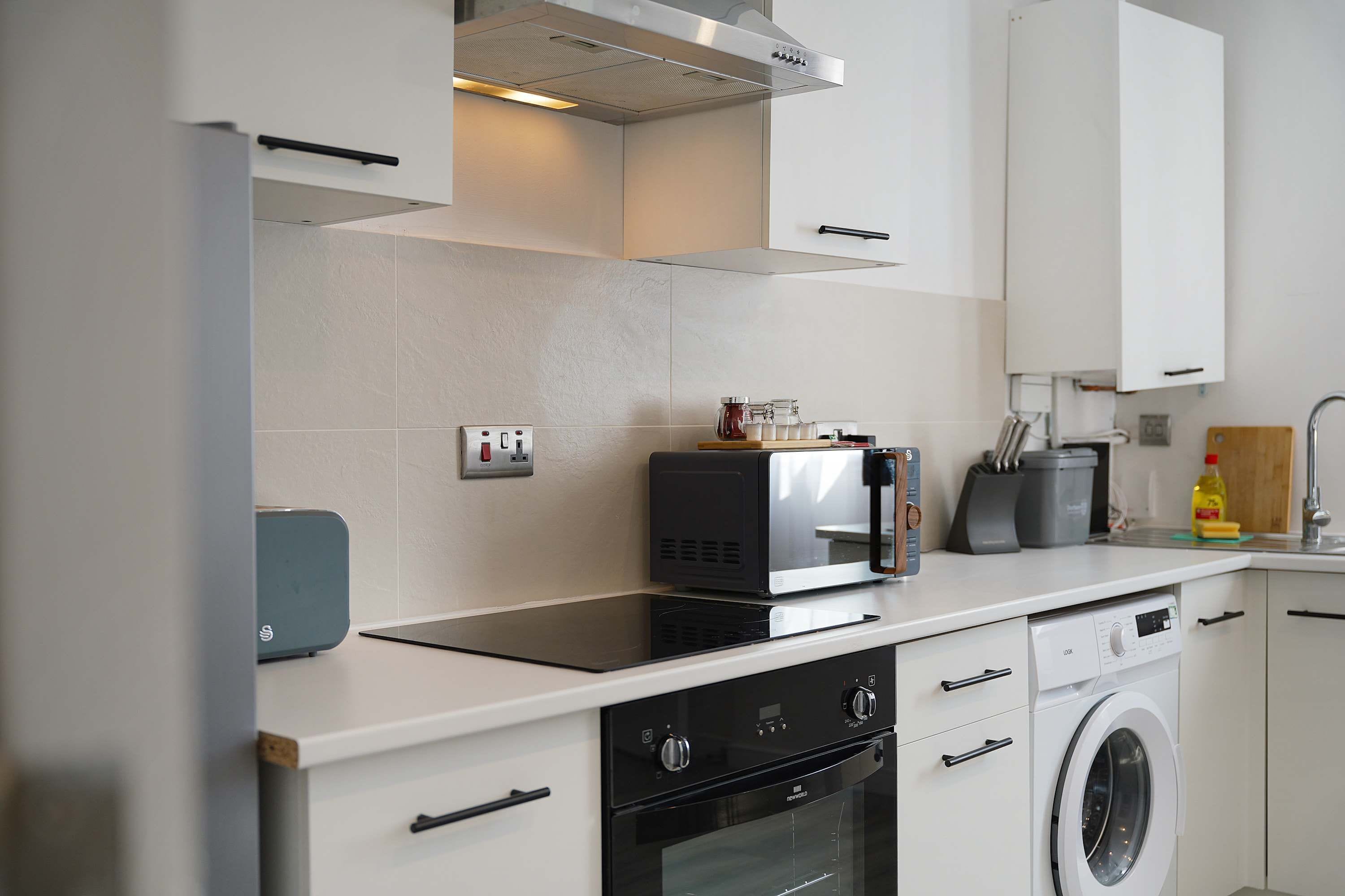 A modern kitchen with a built-in oven, microwave, and dishwasher.