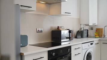 A modern kitchen with a built-in oven, microwave, and dishwasher.