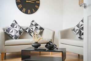 Ein modernes Wohnzimmer mit einer Couch, einem Couchtisch und einer dekorativen Vase mit Pflanzen.