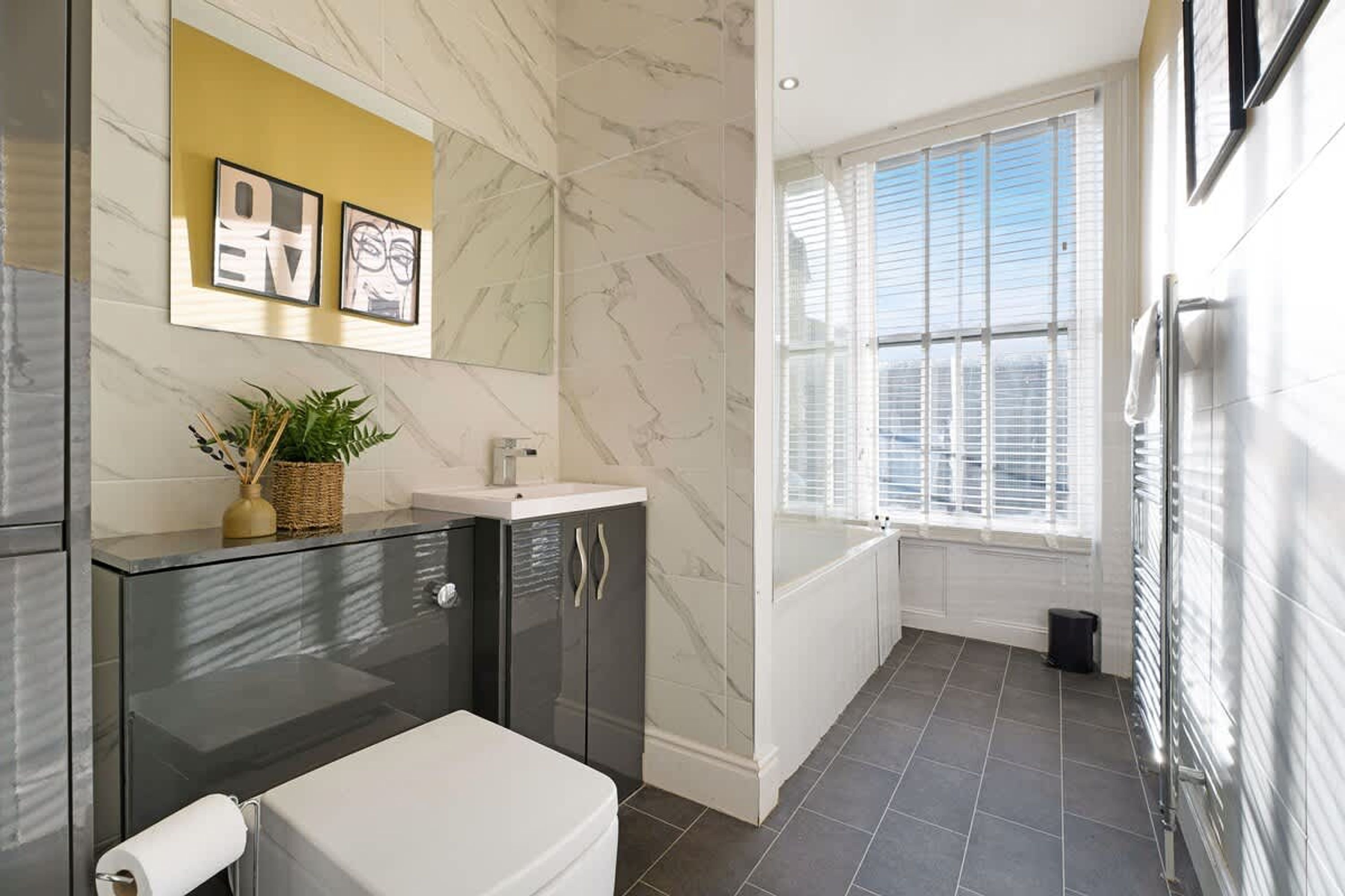 A modern bathroom with a toilet, sink, and shower area.