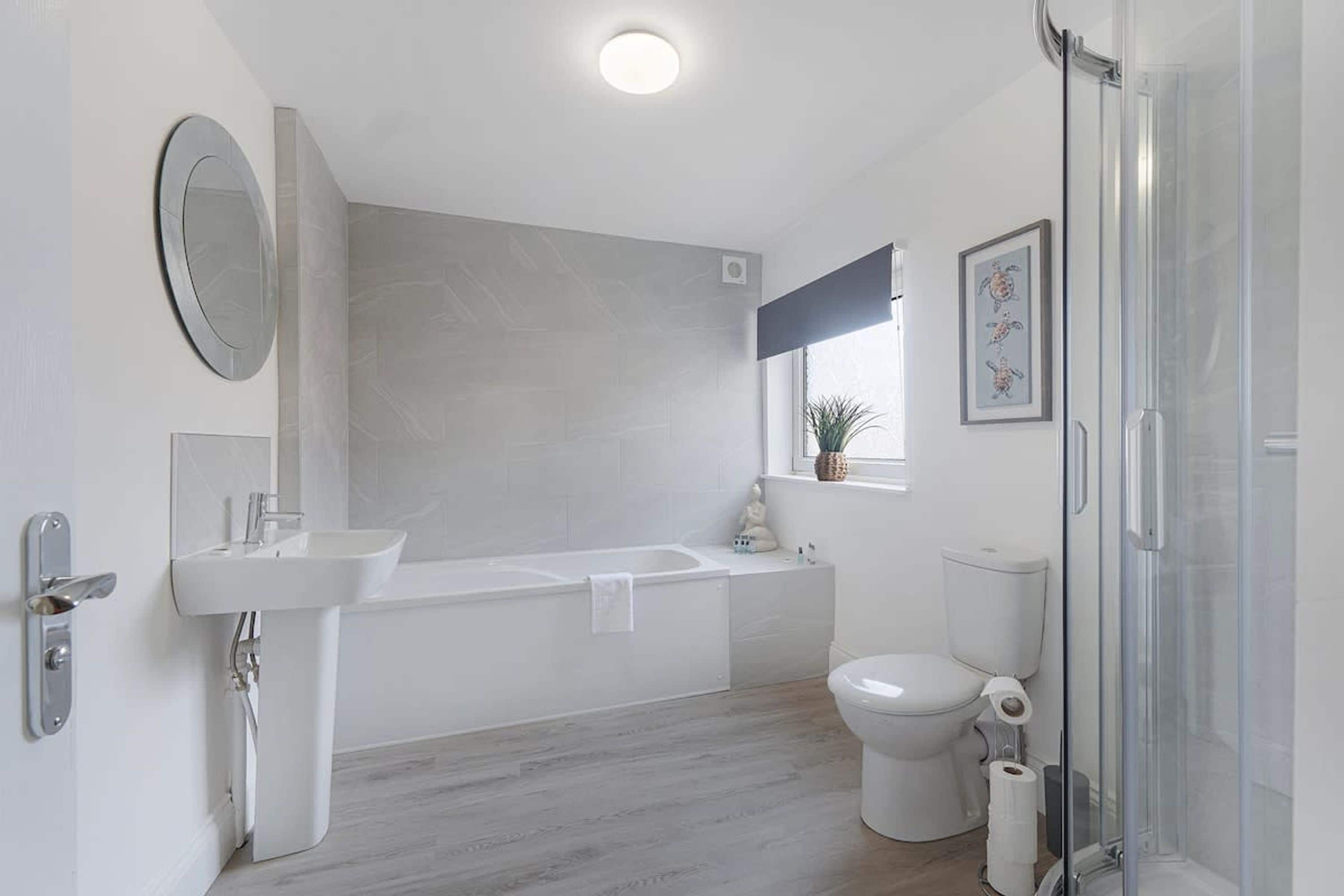 A modern bathroom with a bathtub, toilet, and sink.