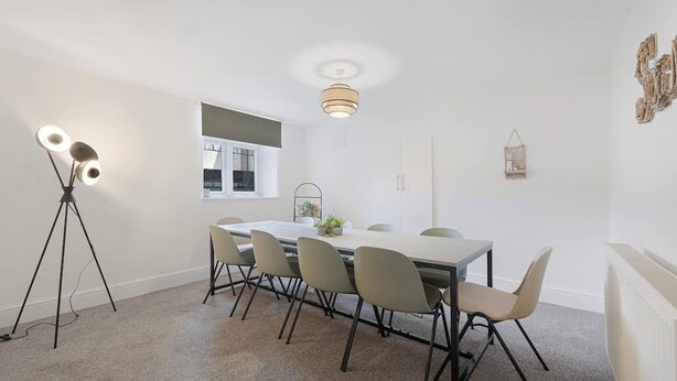 A dining area with a table, chairs, a pendant light, and a floor lamp. - Spacious 6BR Sleeps 12 With Parking (South Shields)