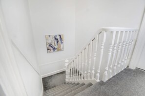 A staircase with white balusters and a carpeted landing. - Family Three Bedroom Home Five Min Walk to Metro (South Shields)