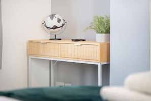 A room with a wooden desk, a globe, a remote control, and a potted plant. - Family Three Bedroom Home Five Min Walk to Metro (South Shields)