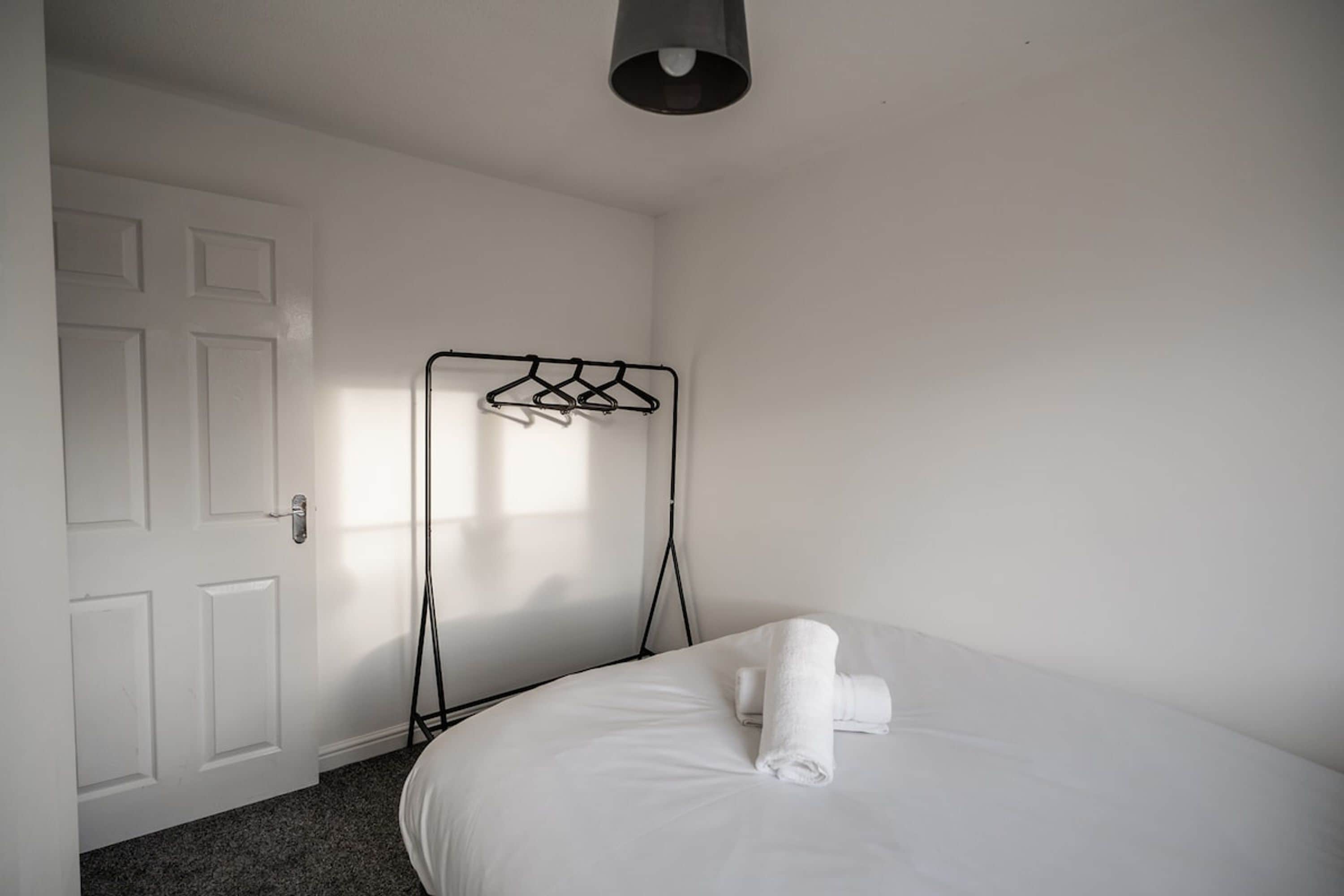 Ein Hotelzimmer mit einem Bett, einer weißen Tür und einem Kleiderständer.