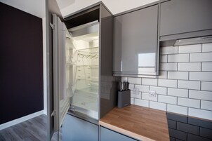Una cocina moderna con horno empotrado, bloque de cuchillos y salpicadero azulejado.