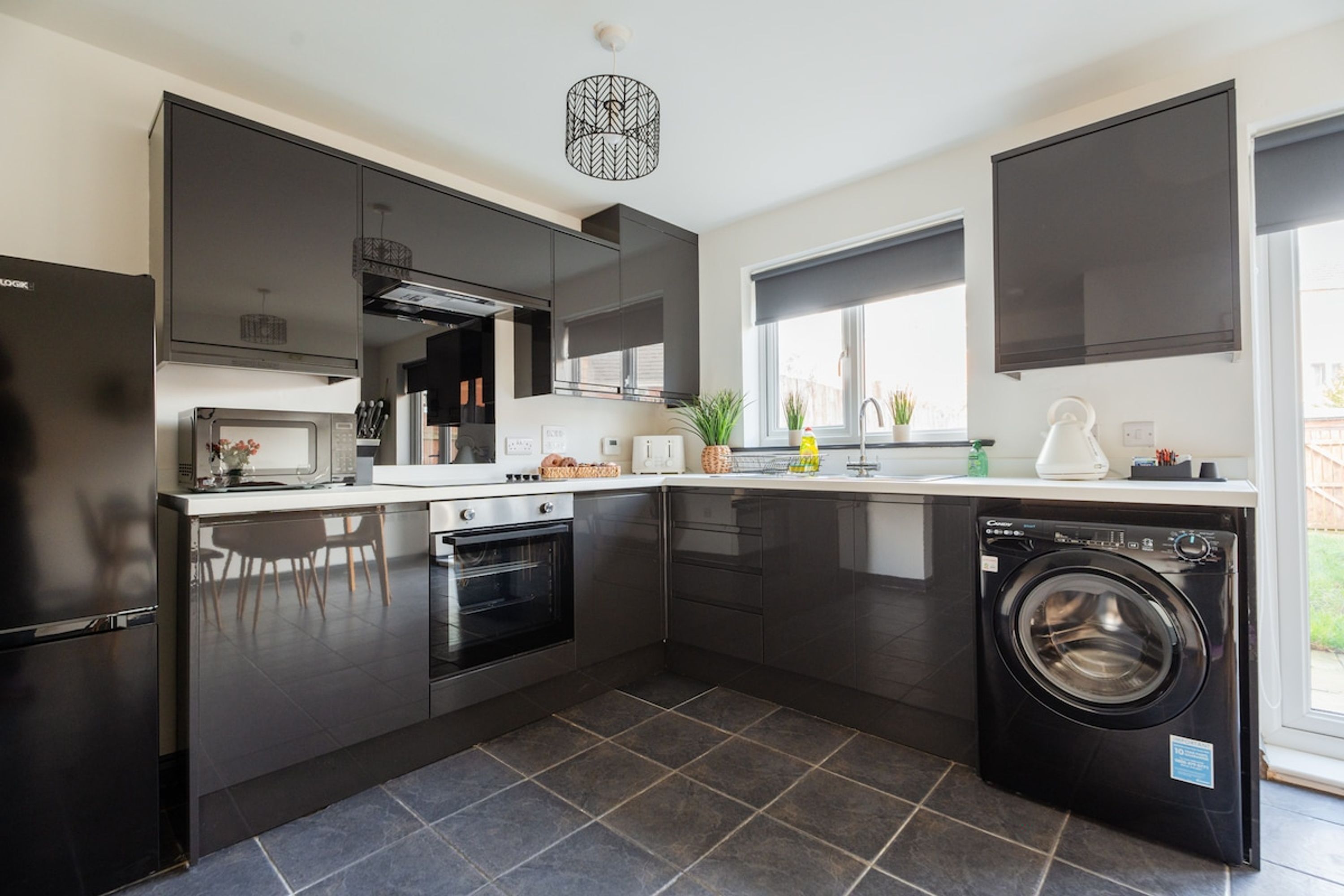 A modern kitchen with a built-in oven, a dishwasher, and a washing machine.
