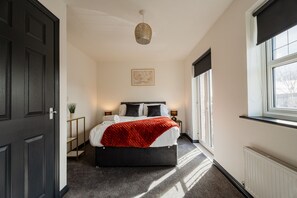 A bedroom with a bed, bedside tables, a window, and a door. - Nightingale House Horizonstays (Stockton-on-Tees)