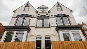 A two-story house with a symmetrical facade, central entrance, and a pitched roof. - 1 Bedroom Studio Apartment Central Middlesbrough (Middlesbrough)