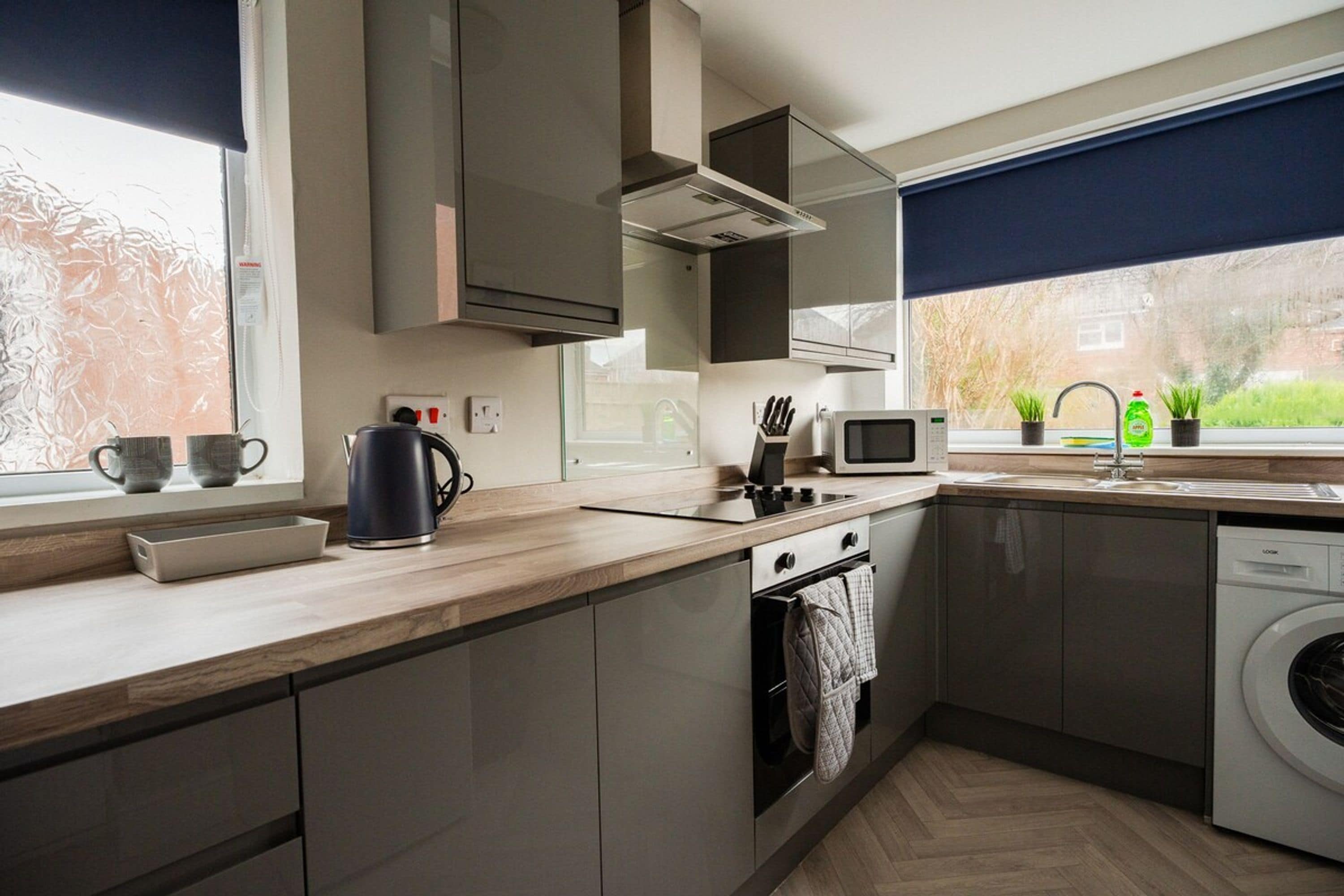 A modern kitchen with a built-in oven, microwave, and dishwasher.