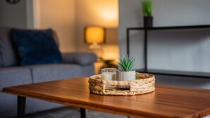 A wooden coffee table with a woven basket containing a candle, a small plant, and a brush. - 3 bed Contractor Accommodation Redcar (Redcar)
