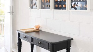 A room with a black table and white brick walls. - Convenient Townsville Stay Near Hospital and CBD (Pimlico)