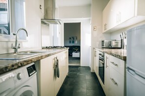 A modern kitchen with a built-in dishwasher, a stove, and a microwave. - Freda House Horizon Stays (Sunderland)