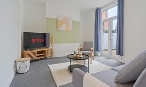 A modern living room with a flat-screen TV, a sofa, a coffee table, and a chair. - Lord House by Horizon Stays (Redcar)