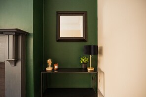 A room with a green wall, a framed picture, a small table with a lamp, and a candle. - Jubilee House Horizon Stays (Middlesbrough)