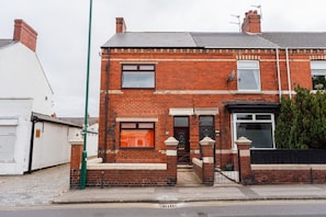 A two-story brick house with a front door, two windows, and a small porch. - The Blue Ember By Horizon Stays (Middlesbrough)