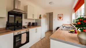 Eine moderne Küche mit weißen Schränken, einem schwarzen Herd und einer Holz Arbeitsplatte.