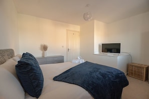 A bedroom with a bed, a television, a dresser, and a window. - Pottery Wharf Horizon Stays (Stockton-on-Tees)