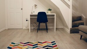A room with a white door, a desk with a chair, a small plant, and a staircase. - Thornwood House Horizon Stays (Stockton-on-Tees)