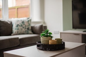 A modern living room with a sofa, a coffee table, and a potted plant. - Buckingham House Horizon Stays (Redcar)