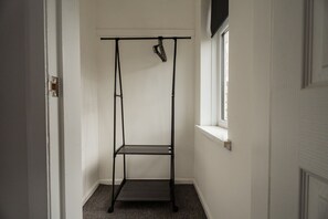 A narrow hallway with a black metal rack against the wall and a window on the right. - Barnaby House Horizon Stays (Middlesbrough)
