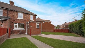 A residential property with a brick house, a paved driveway, and a well-maintained lawn. - Stunning 3BR Equipped Kitchen By Stay With Us (Chester-le-Street)