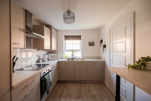 A kitchen with a stove, microwave, and sink. - The Norton Nook Horizon Stays (Stockton-on-Tees)