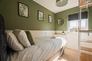A bedroom with a bed, pillows, a nightstand, a mirror, and a window. - The Norton Nook Horizon Stays (Stockton-on-Tees)