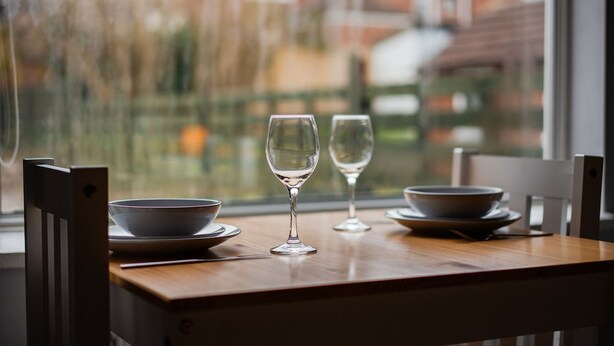 A dining table with two bowls, two wine glasses, and a chair. - Humber House Thornaby (Stockton-on-Tees)
