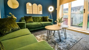 A living room with a green sofa, a round coffee table, and a floor lamp. - Dalkeith House Horizon Stays 4 Bed (Hartlepool)