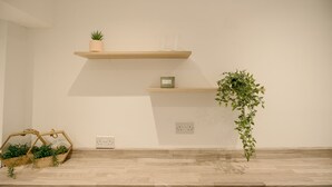 A minimalist room with wooden shelves, a potted plant, and a small wooden box. - Canterbury House Horizonstays (Redcar)