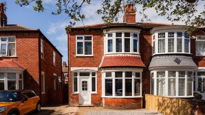 A two-story brick house with a bay window and a front door. - Redcar House Horizon Stays (Redcar)