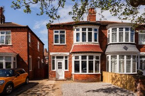 A two-story brick house with a bay window and a front door. - Redcar House Horizon Stays (Redcar)