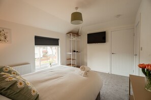 A bedroom with a bed, a window, a wardrobe, a television, and a plant. - Laburnum House by Horizon Stays (Redcar)