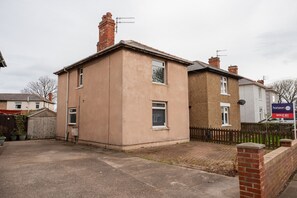A two-story residential building with a flat roof, a brick chimney, and a satellite dish. - Laburnum House by Horizon Stays (Redcar)